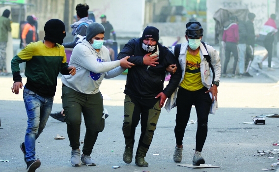 محتجون عراقيون يسعفون احد الجرحى - أ ف ب - أرشيفية